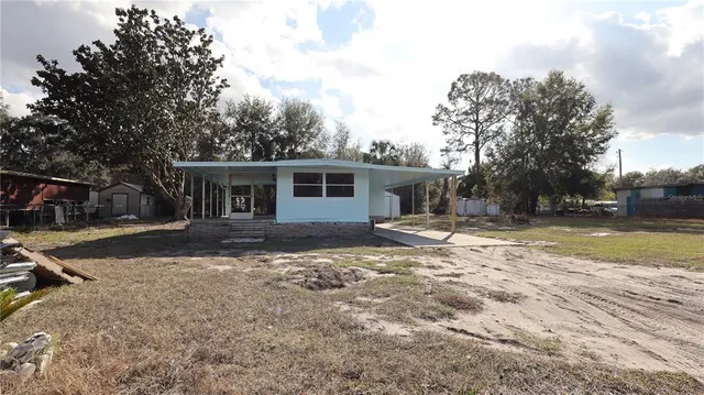a view of a house with backyard and sitting area