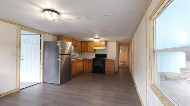 a kitchen with refrigerator cabinets and wooden floor