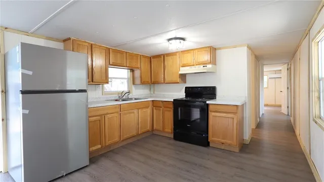 a kitchen with granite countertop a refrigerator stove top oven and sink