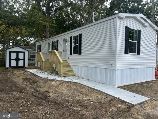 a view of a house with a yard and large tree