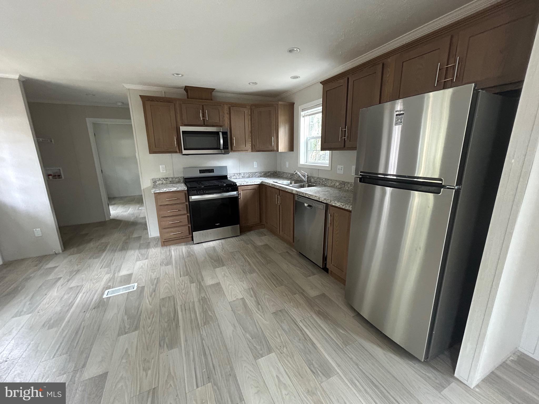 2501 Tilton Road, Unit 312 Egg Harbor Township, NJ 08234 - Photo 9 of 18 a kitchen with granite countertop a refrigerator stove and wooden floor