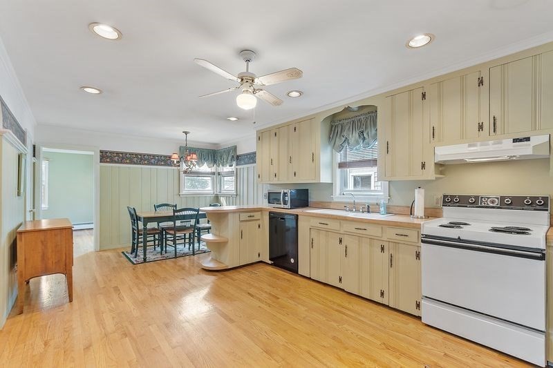 68 Spring Road Nahant, MA 01908 - Photo 7 of 23 a kitchen with stainless steel appliances kitchen island granite countertop a wooden cabinets a stove a sink a dining table and chairs