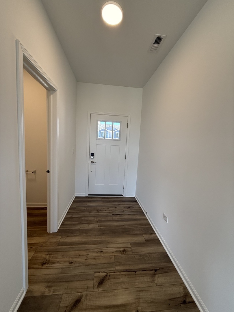 10232 McMahon Way, Unit 10232 Huntley, IL 60142 - Photo 3 of 22 a view of a room with wooden floor and staircase
