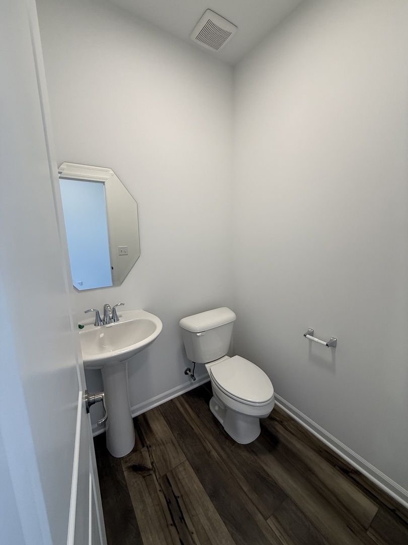 10232 McMahon Way, Unit 10232 Huntley, IL 60142 - Photo 4 of 22 a bathroom with a toilet a sink and mirror