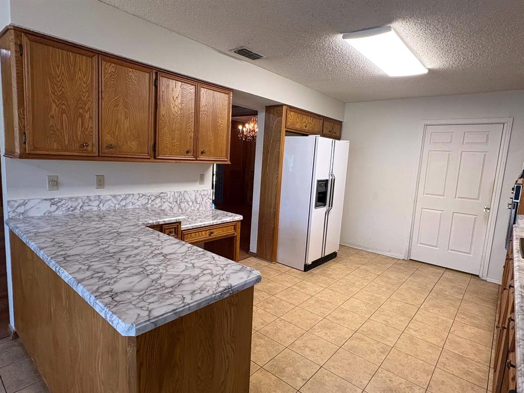 27 Sundown Trail Star Harbor, TX 75148 - Photo 11 of 32 a kitchen with kitchen island granite countertop wooden cabinets and granite counter tops