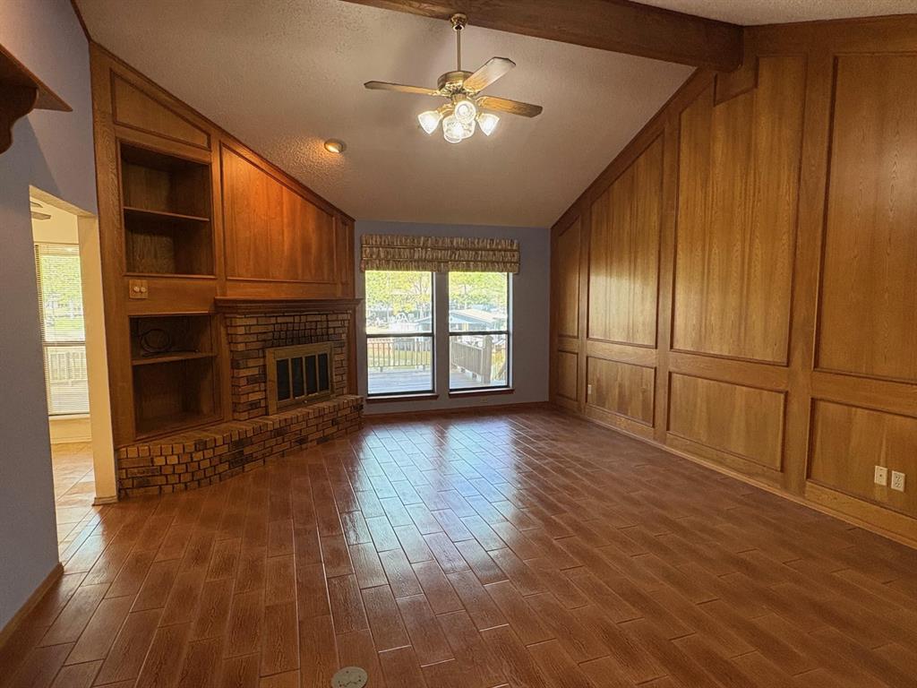 27 Sundown Trail Star Harbor, TX 75148 - Photo 6 of 32 an empty room with wooden floor fireplace and windows