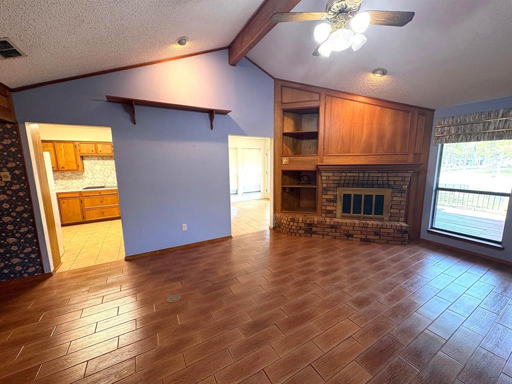 27 Sundown Trail Star Harbor, TX 75148 - Photo 8 of 32 an empty room with windows fireplace and wooden floor