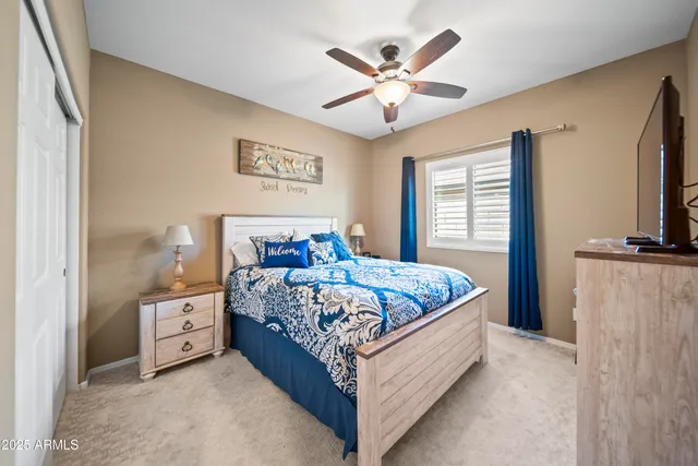 a bedroom with a large bed and a flat tv screen on dresser