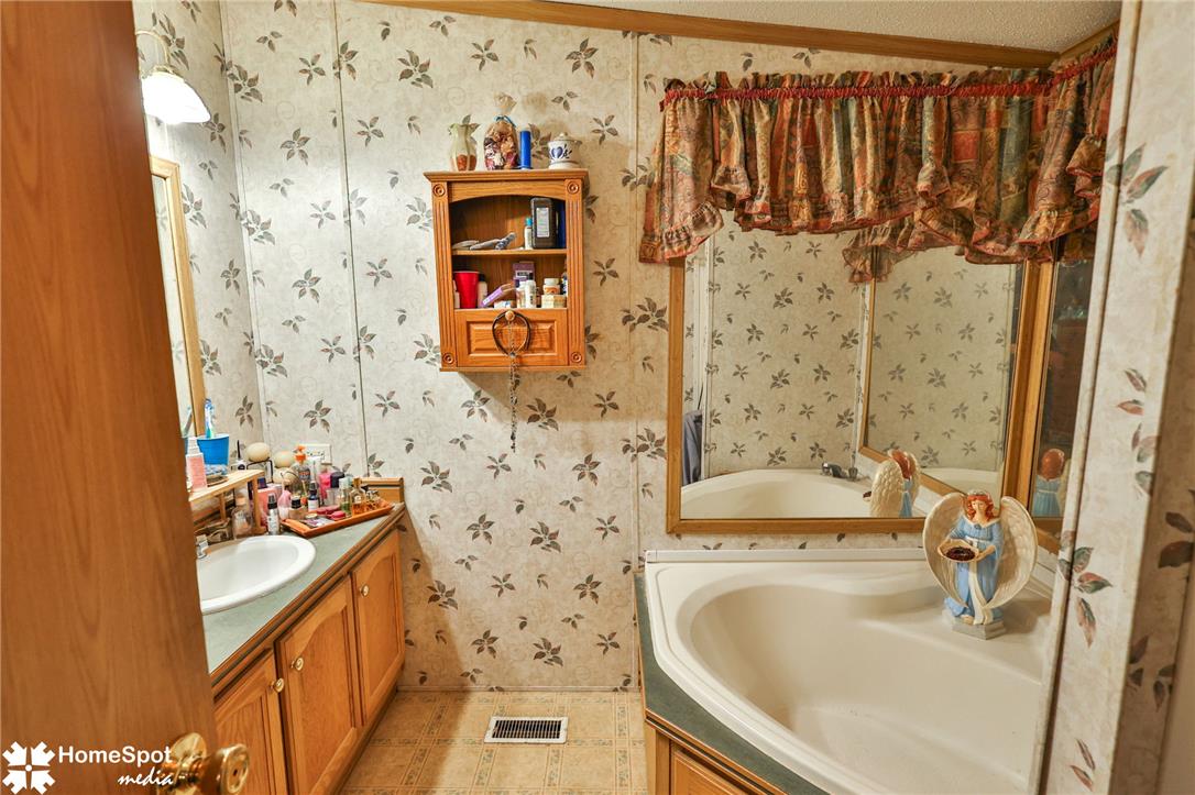 3795 Rhoades Road Kempton, PA 19529 - Photo 11 of 42 A well-maintained bathroom with a deep soaking tub and vanity, featuring a classic tile floor.