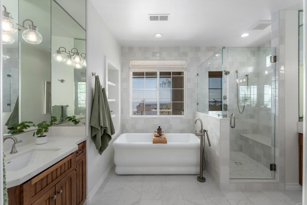 1483 Neptune Avenue Encinitas, CA 92024 - Photo 27 of 46 a spacious bathroom with a bathtub shower sink and mirror