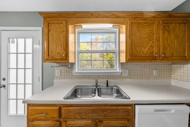 a kitchen with stainless steel appliances granite countertop a sink and a window
