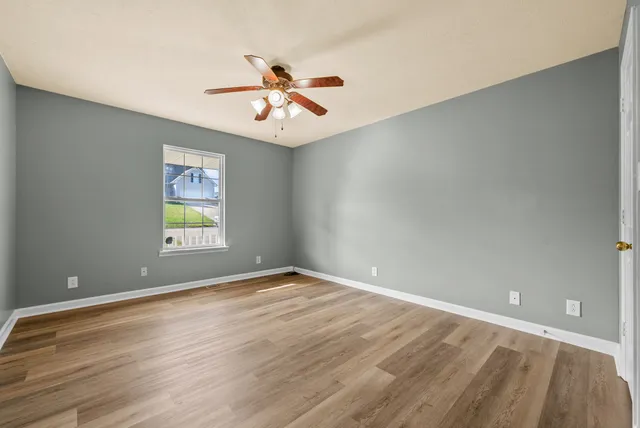 wooden floor in an empty room with a window