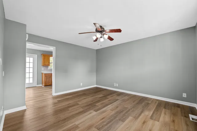 a view of a room with wooden floor and a ceiling fan