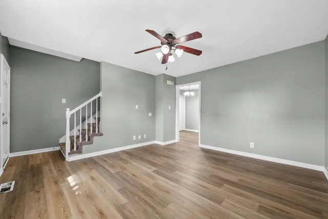a view of an empty room with window and wooden floor