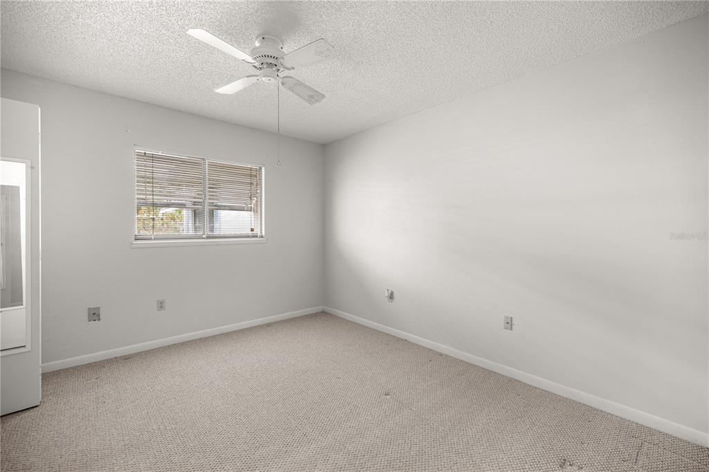 9230 Southwest 101st Lane Ocala, FL 34481 - Photo 20 of 31 an empty room with windows and ceiling fan