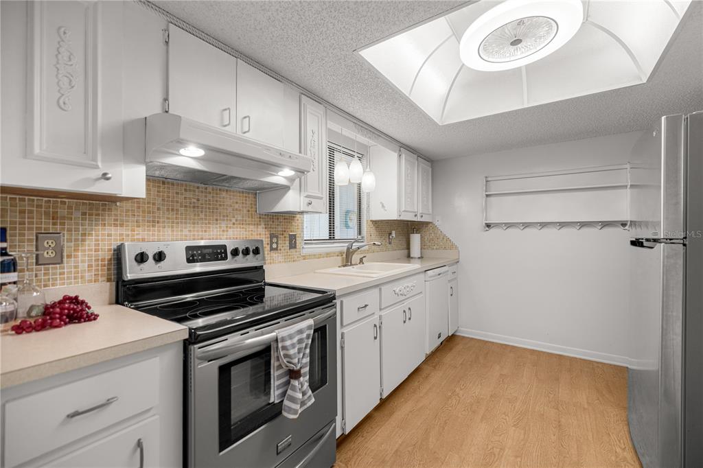 9230 Southwest 101st Lane Ocala, FL 34481 - Photo 6 of 31 a kitchen with a stove and white cabinets