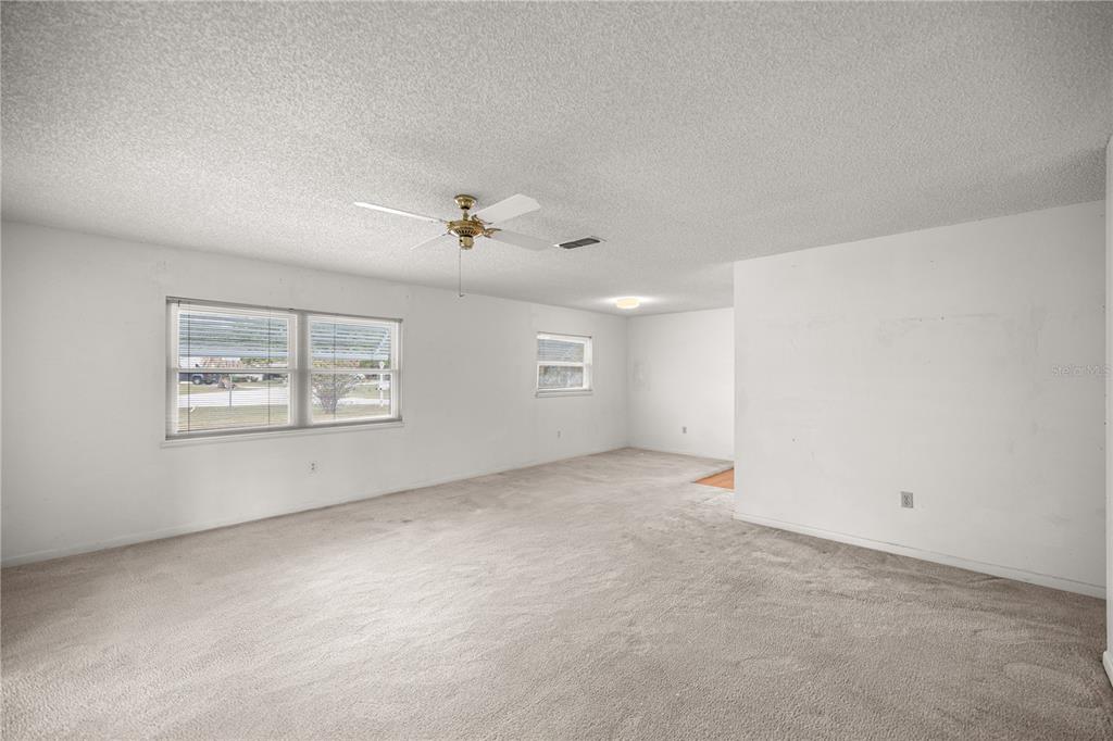 9230 Southwest 101st Lane Ocala, FL 34481 - Photo 10 of 31 an empty room with windows and ceiling fan view