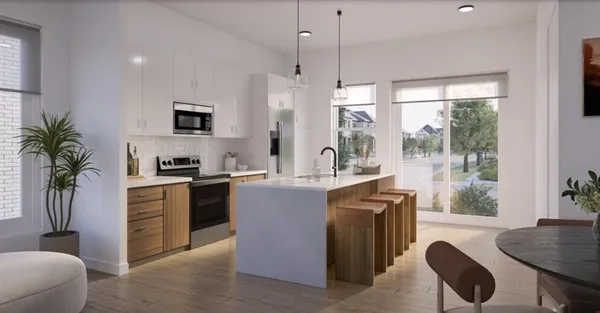 a kitchen with stainless steel appliances a refrigerator a stove a sink a dining table and chairs with wooden floor