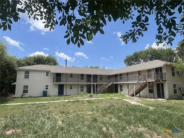 a view of a house with backyard and a tree