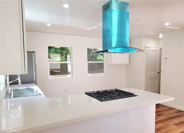 a kitchen with stainless steel appliances a white stove top oven a sink and a refrigerator