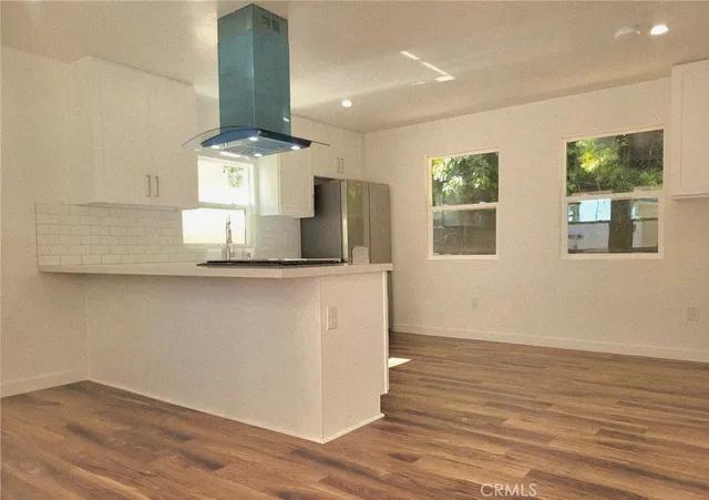 a kitchen with a refrigerator a stove a sink and a hard wood floor
