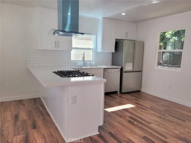 a kitchen with wooden floors and appliances