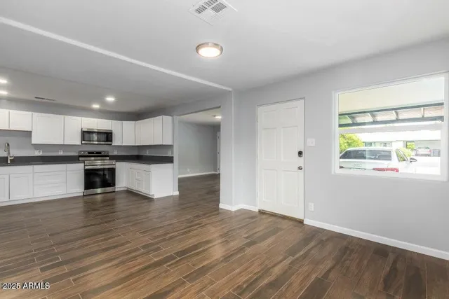 a view of kitchen with wooden floor and electronic appliances