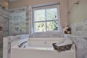 a bathroom with a tub and a shower