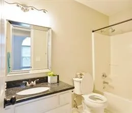 a bathroom with a granite countertop sink toilet and shower