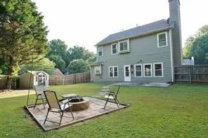 a backyard of a house with table and chairs