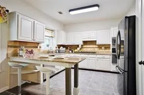 a kitchen with stainless steel appliances granite countertop a refrigerator sink and stove