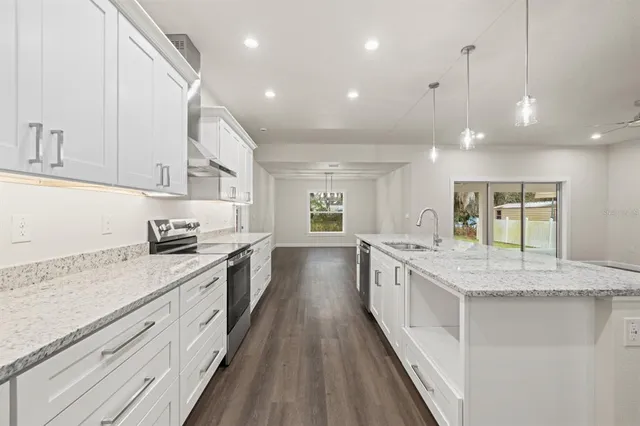 a large kitchen with granite countertop lots of counter space and a sink