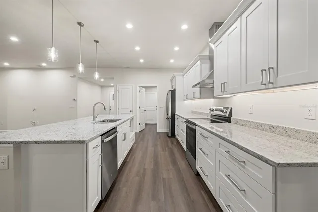 a large kitchen with stainless steel appliances granite countertop a lot of counter space