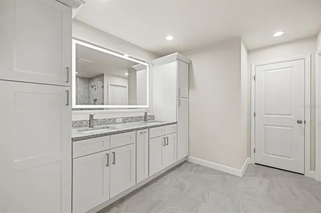 a bathroom with a granite countertop sink and a mirror