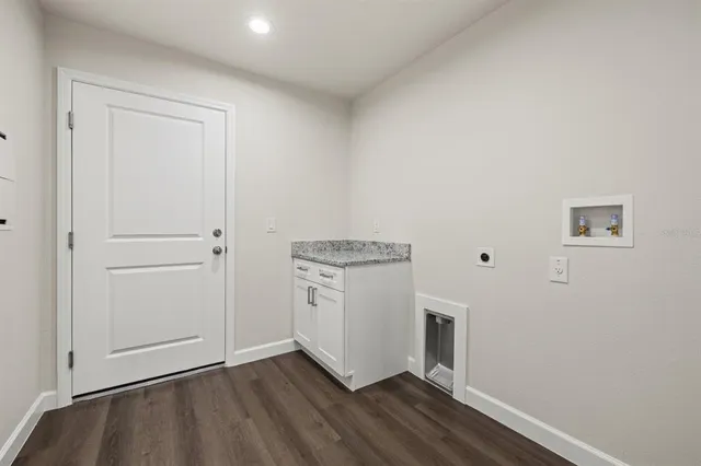 an empty room with wooden floor sink and closet
