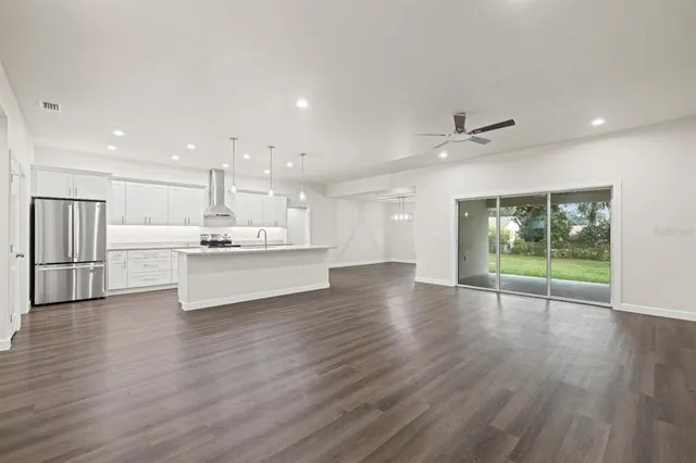 a view of kitchen with refrigerator and wooden floor