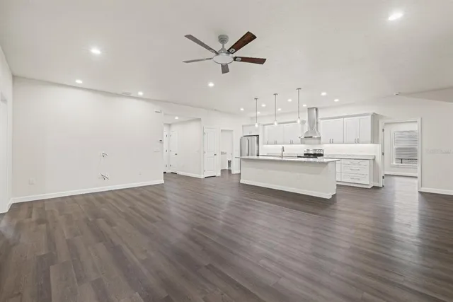a view of kitchen with cabinets wooden floor and stainless steel appliances
