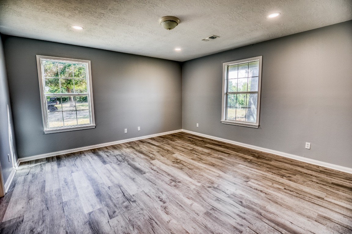 2700 Quarry Road Brenham, TX 77833 - Photo 11 of 35 an empty room with wooden floor and windows