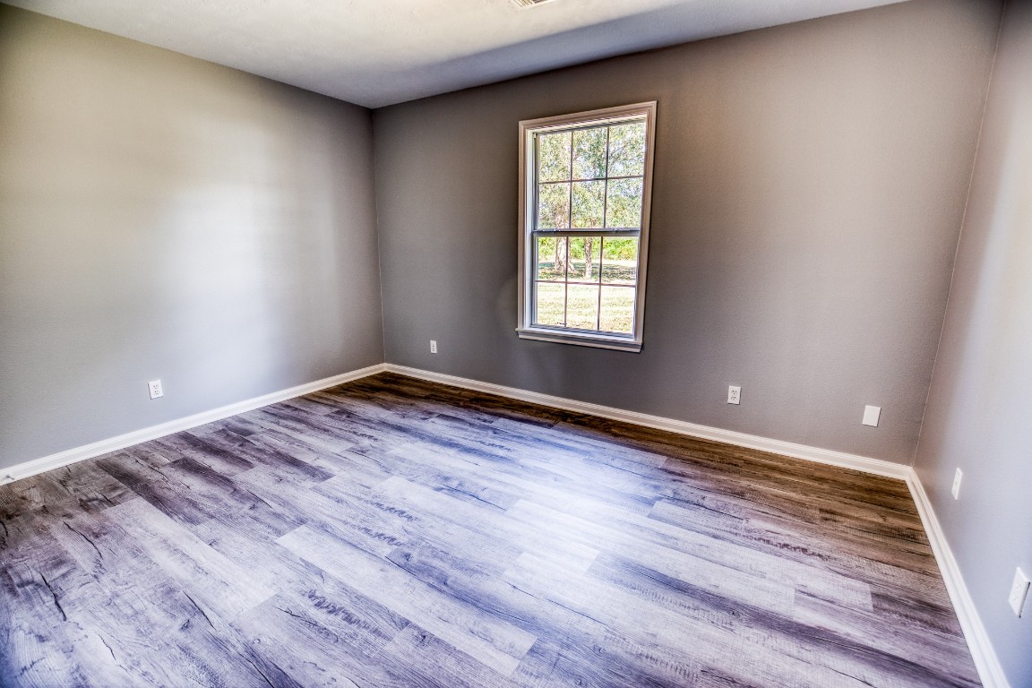 2700 Quarry Road Brenham, TX 77833 - Photo 14 of 35 an empty room with wooden floor and windows