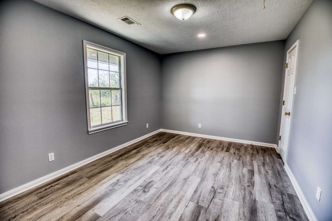 2700 Quarry Road Brenham, TX 77833 - Photo 16 of 35 an empty room with wooden floor and windows