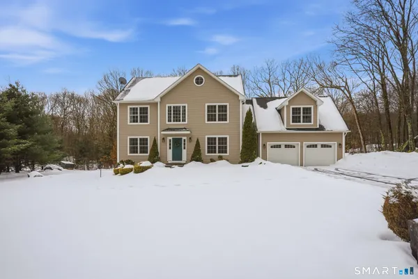 a front view of a house with a yard covered in snow