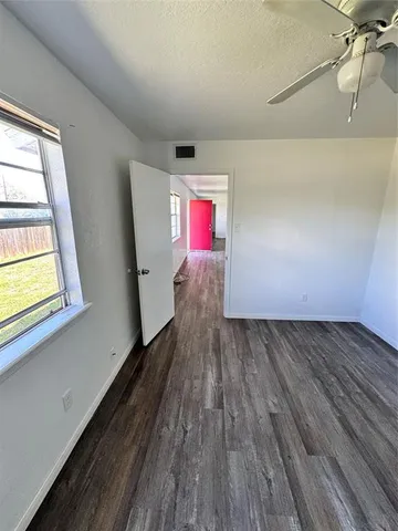 a view of hallway with window and wooden floor