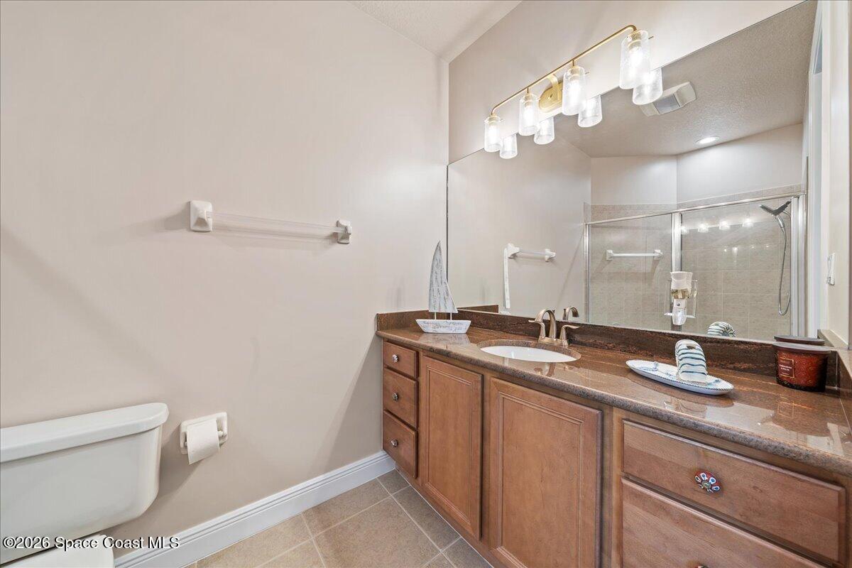 6005 Highway 1, Unit 101 Rockledge, FL 32955 - Photo 26 of 57 a bathroom with a granite countertop sink a toilet and a mirror