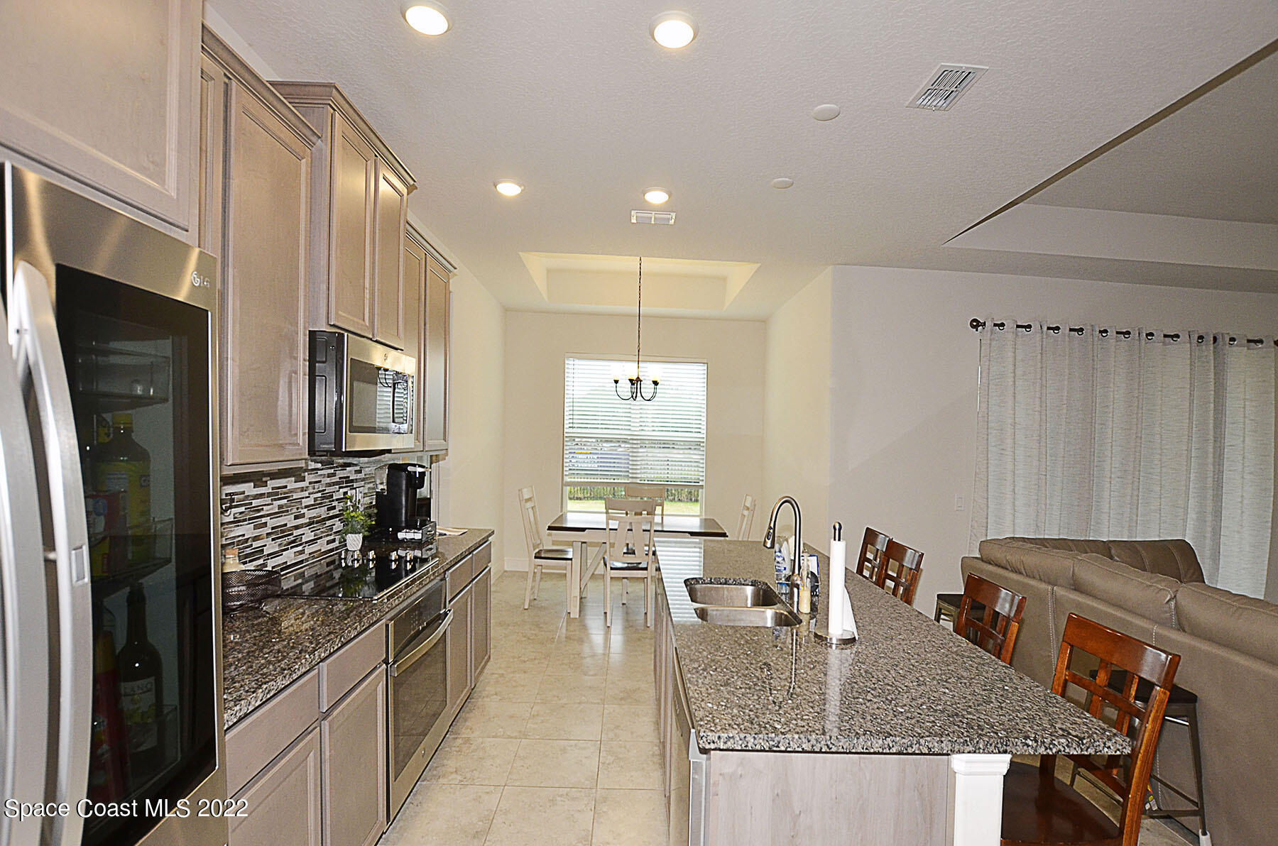 1923 Killian Drive Palm Bay, FL 32905 - Photo 19 of 44 a kitchen with stainless steel appliances granite countertop a stove a refrigerator a oven a sink with a dining table and chairs