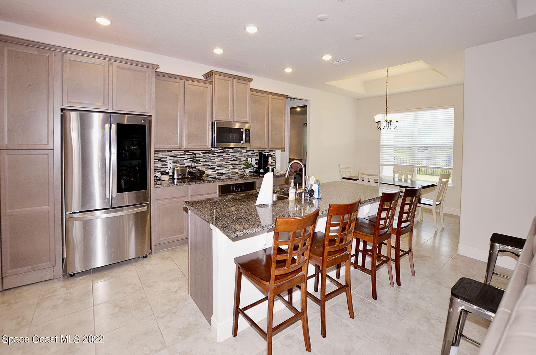 1923 Killian Drive Palm Bay, FL 32905 - Photo 20 of 44 a kitchen with stainless steel appliances kitchen island granite countertop a refrigerator and a stove top oven