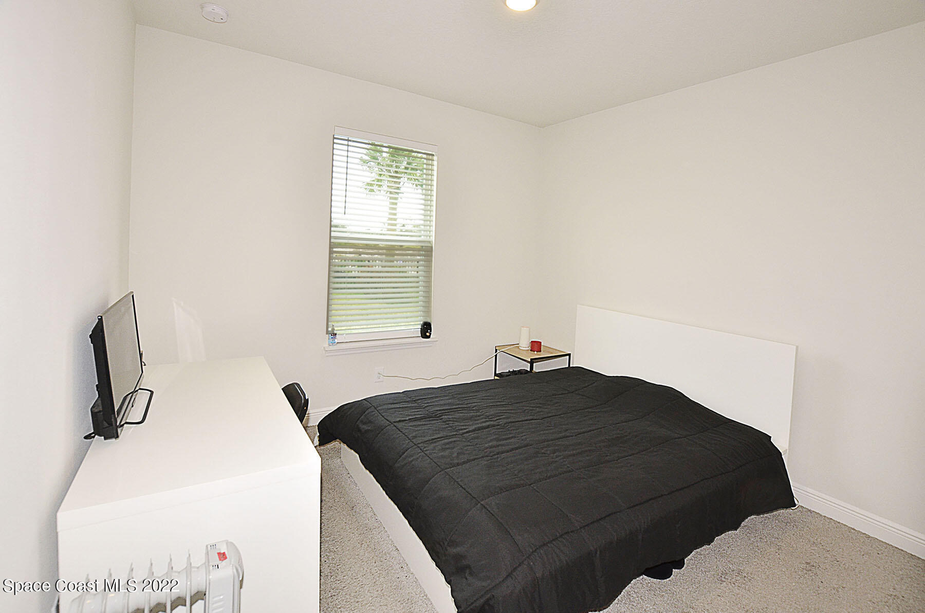 1923 Killian Drive Palm Bay, FL 32905 - Photo 33 of 44 a bedroom with a bed and a flat tv screen on a dresser