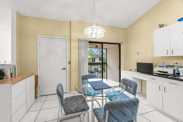 a kitchen with stainless steel appliances kitchen island granite countertop dining table chair and a refrigerator
