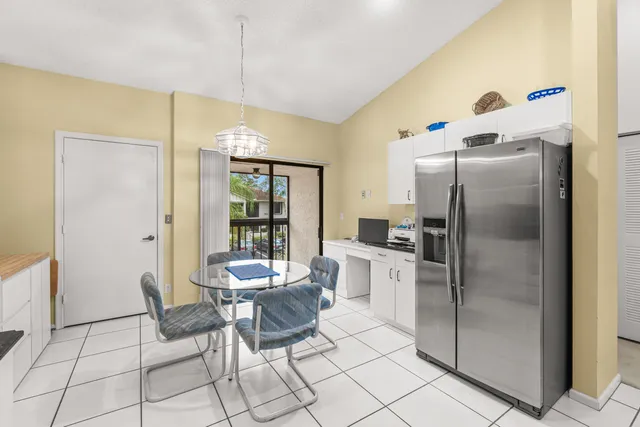 a kitchen with stainless steel appliances kitchen island granite countertop a sink a stove a refrigerator cabinets and chairs