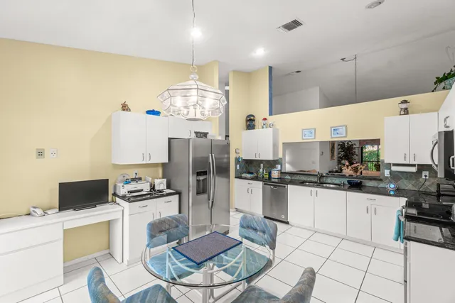 a kitchen with granite countertop a stove a sink and a refrigerator