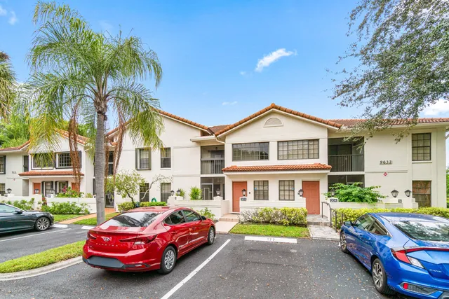 a front view of a house with garden and trees